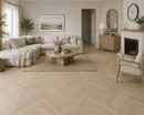 Nordic Oak Herringbone LVP installed in a living room with beige sectional sofa, wooden coffee table, and decorative elements.